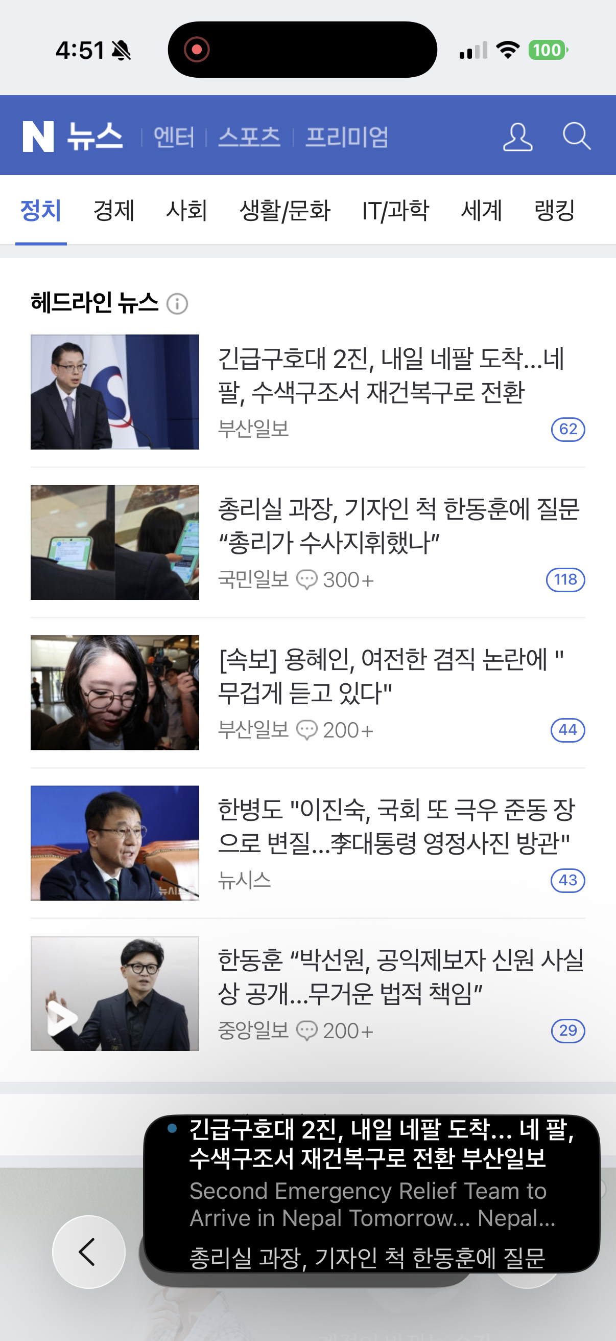 The floating window over the Naver News front page: a red recording dot in the Dynamic Island, the Politics tab's headline list, and a dark caption panel at the bottom holding the first headline in Korean, its English translation, and the start of the next one